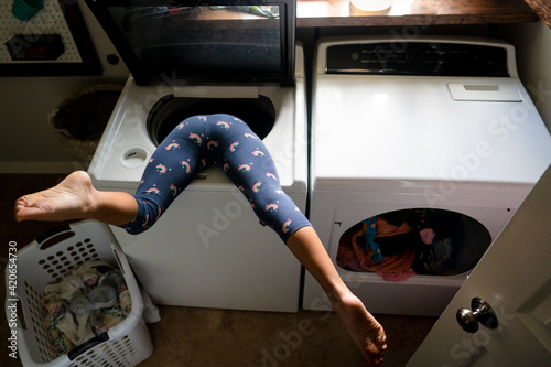 Child upside down in washing machine with legs kicked up