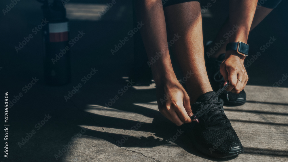 Woman tying her shoelaces, getting ready to exercise wallpaper