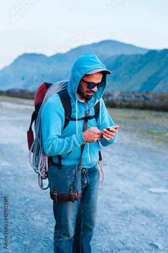 Male climber using smartphone in countryside