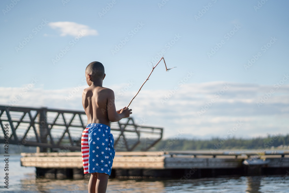 Back view of boy in swimsuit by water Back view of boy in swimsuit by water