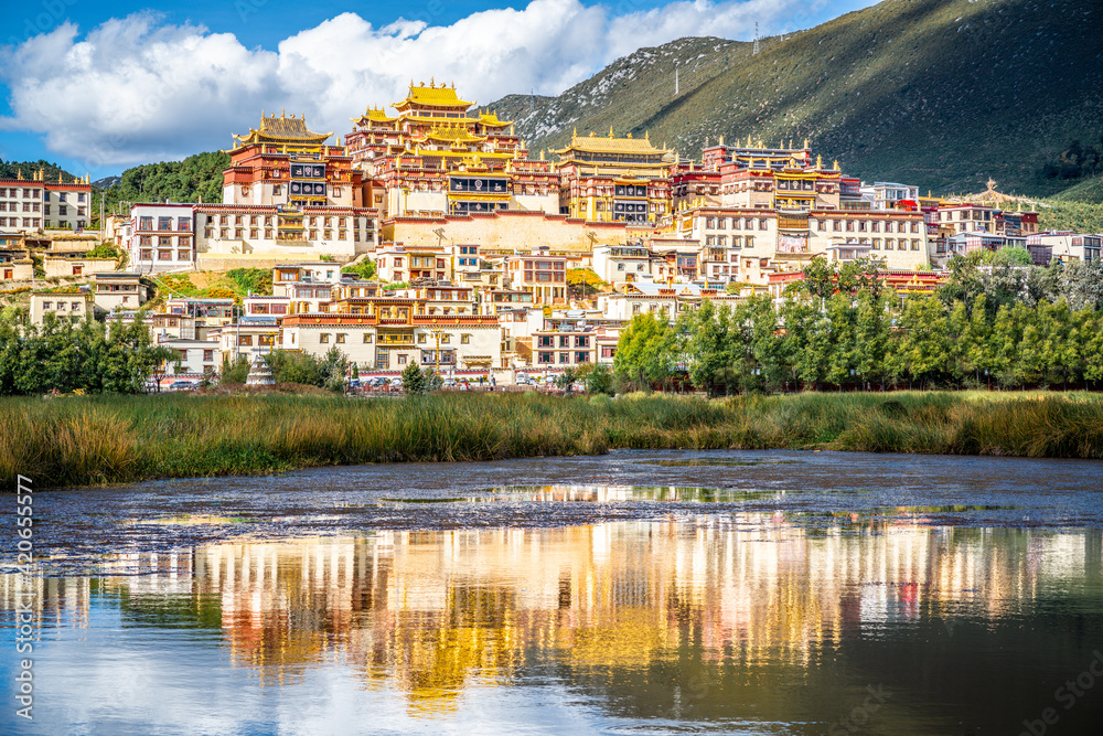 Ganden Sumtseling monastery with beautiful water reflection on lake Shangri-La Yunnan China