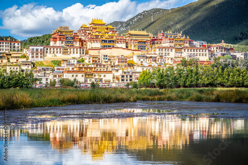 Ganden Sumtseling monastery with beautiful water reflection on lake Shangri-La Yunnan China