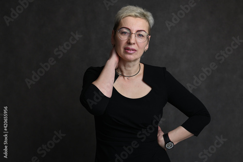 Portrait of caucasian blonde woman in glasses on black background