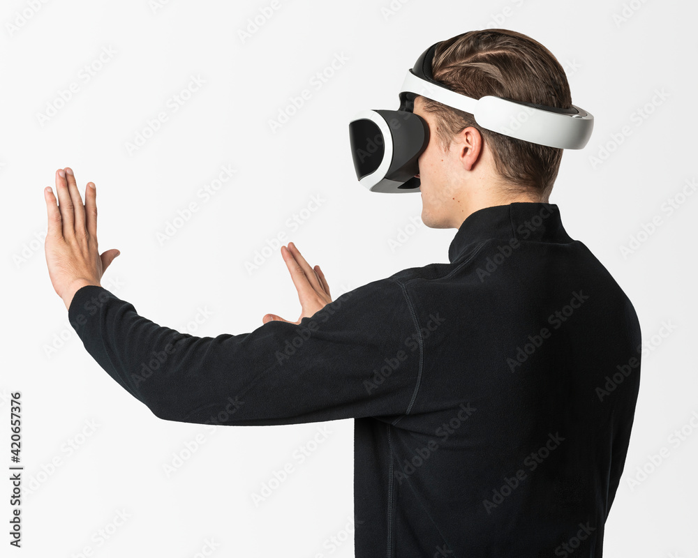 Man in VR headset touching invisible screen Man in VR headset touching invisible screen