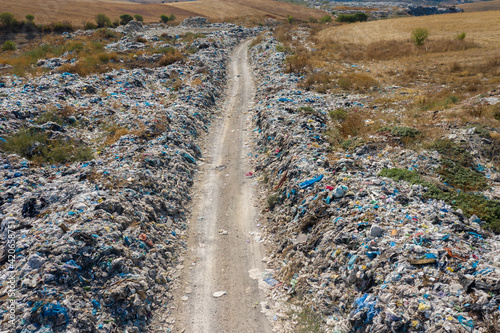 road to a garbage heap full on plastic pollution photo