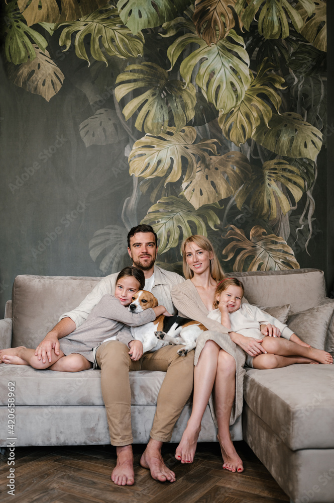 Happy family with dog resting on couch Happy family with dog resting on couch
