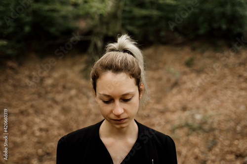 Portrait of thoughtful Young woman in forest during autumn photo