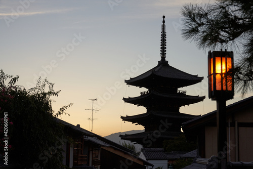 Traditional oriental pagoda in garden against sunset sky photo