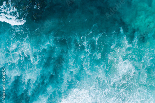 Aerial views over crashing sea waves on rocking ocean crop photo