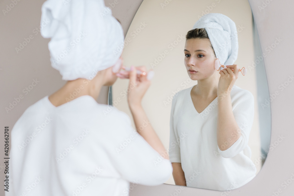 Woman massaging face with stone roller Woman massaging face with stone roller
