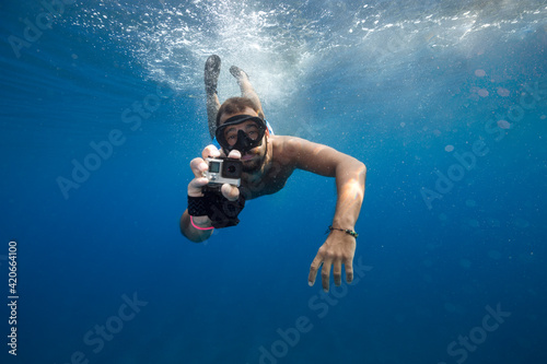 Man filming with action cam underwater