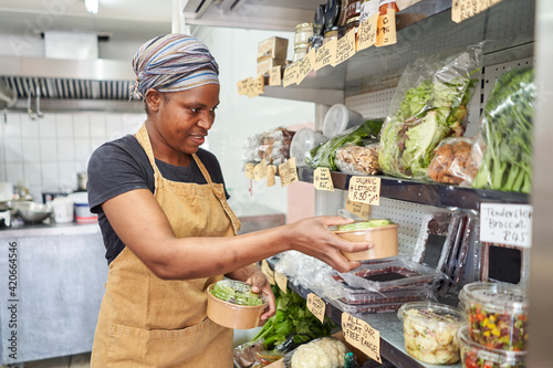 Deli owner packing produce in store