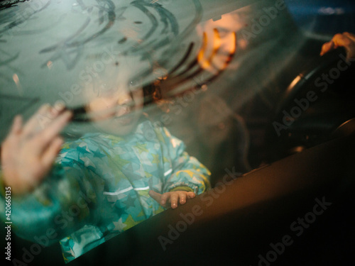 Kid and father inside a car with steamy windows