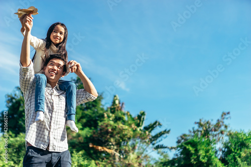 Daughter sits on his father's neck.The family enjoyed a holiday Holiday over beautiful nature.Concept People and family.