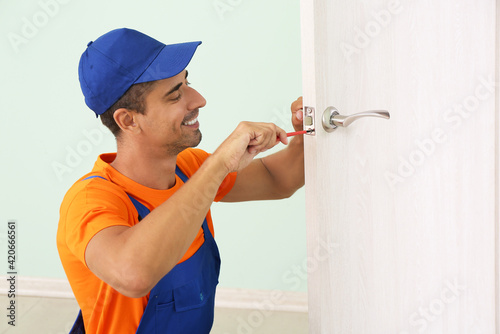 Worker repairing door lock ...