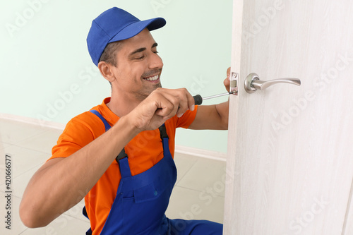 Worker repairing door lock ...