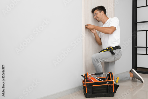 Construction worker repairing door indoors photo