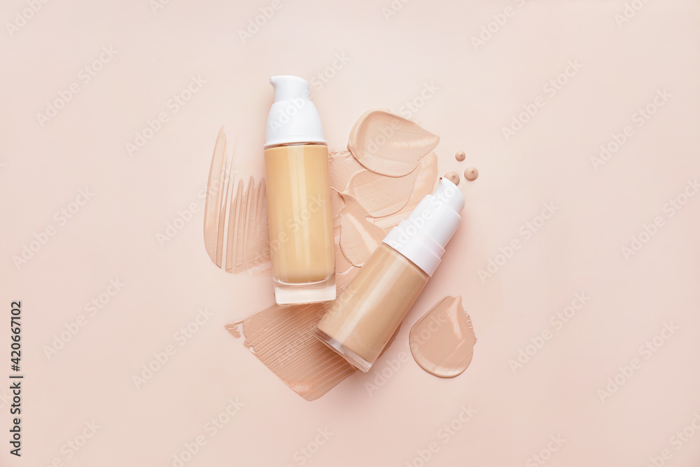 Bottles of makeup foundation and samples on color background - obrazy, fototapety, plakaty 