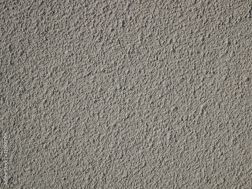 Detail of bumpy concrete wall painted in gray color