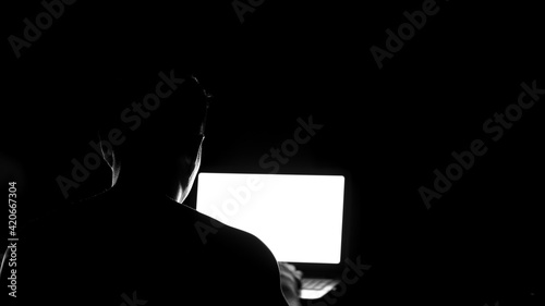 Schilderij op canvas Low key silhouette of male profile watching at laptop screen