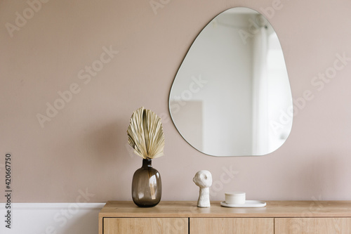 Mirror and wooden cabinet with decorative elements in room photo