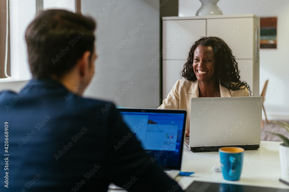 Serious black woman taking notes in planner during work in office Serious black woman taking notes in planner during work in office