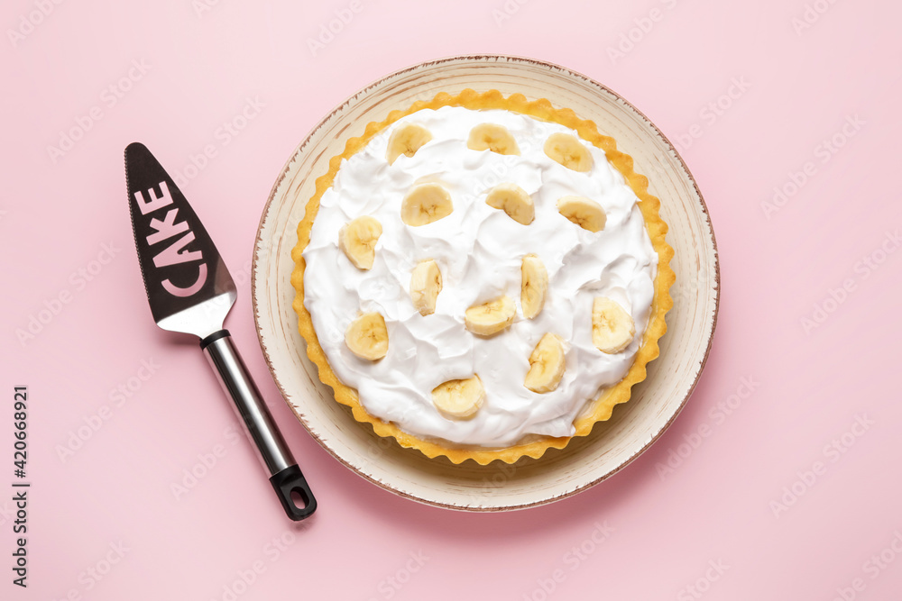 Plate with tasty banana pie and spatula on color background Plate with tasty banana pie and spatula on color background