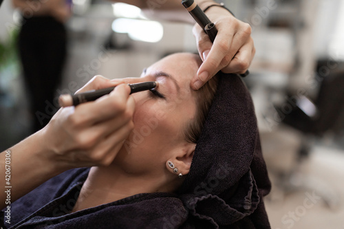 beautician repairing eyebrows.