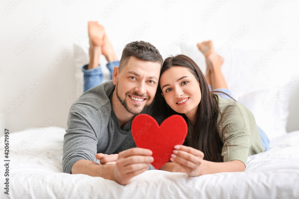 Happy couple with red heart at home Happy couple with red heart at home