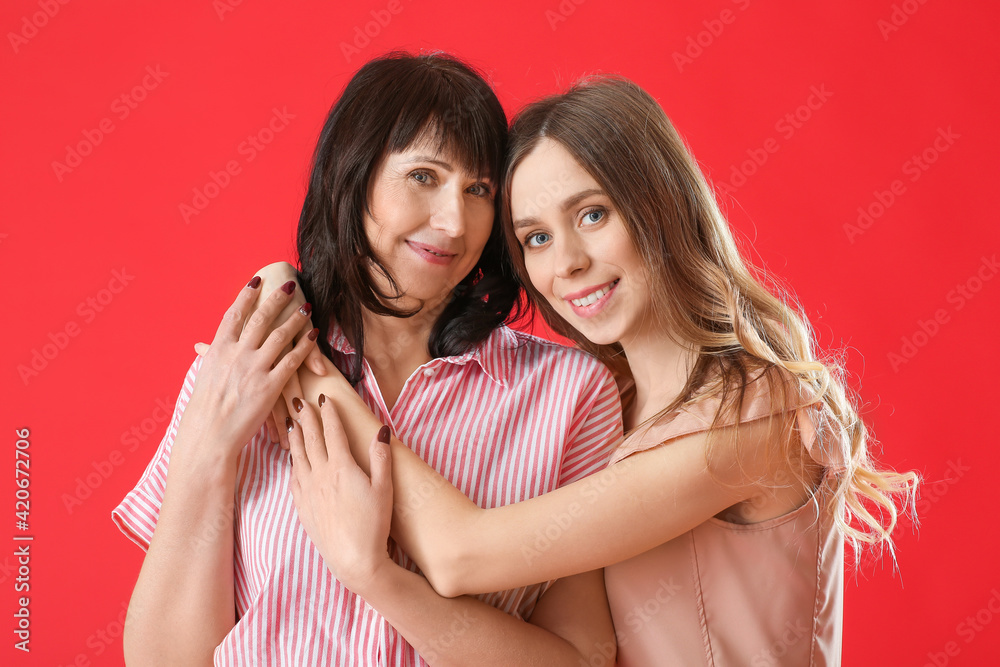 Young woman and her mother on color background Young woman and her mother on color background