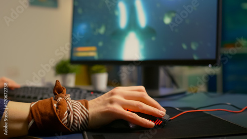Close up of professional mouse in gaming home studio late at night. Pro gamer playing space shooter game using RGB powerful equipment for digital tournament