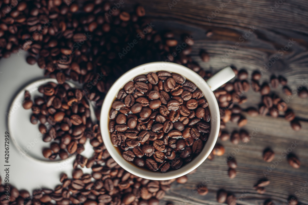 Fototapeta premium Hot drink in a saucer and sprinkled grain on a wooden table top view