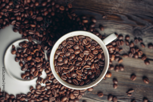 Hot drink in a saucer and sprinkled grain on a wooden table top view