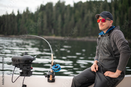 Smiling man on a boat with a fishing rod