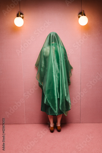 woman with green outfit in a pink room photo