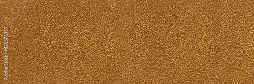 The texture of the sand-washed gold wall.