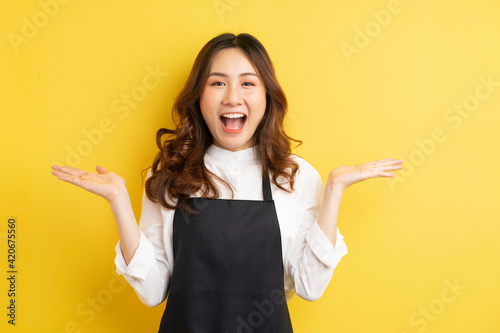 Beautiful housewife with gesture isolated on yellow background photo