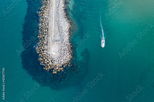 boat enters a harbour of turquoise and teal colour photo