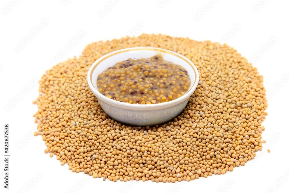 Traditional dijon mustard sauce in a bowl with mustard seeds. Traditional dijon mustard sauce in a bowl with mustard seeds.