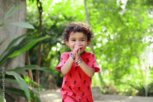 A small Hindu Indian resident child smiling with his hands on his face