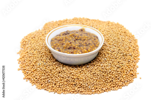 Traditional dijon mustard sauce in a bowl with mustard seeds.