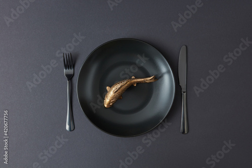 Served table set with golden fish on ceramic plate.
