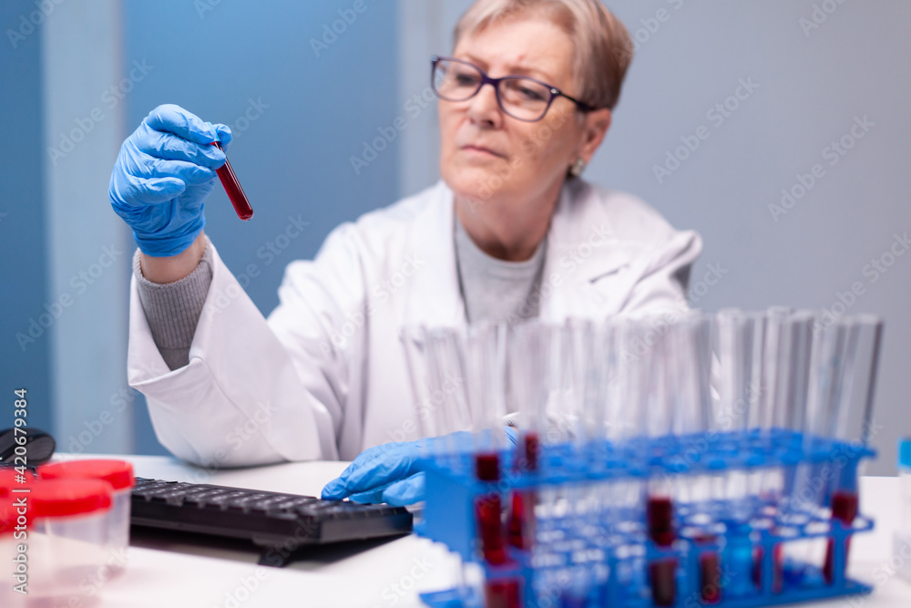 Biochemist scientist in white coat discovering genetic infection and analysing a blood tube. Specialist doctor discovery scientifc experiment with professional technology equipment industry Biochemist scientist in white coat discovering genetic infection and analysing a blood tube. Specialist doctor discovery scientifc experiment with professional technology equipment industry