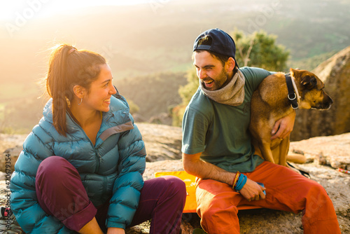 Climber friends having fun resting on stones in winter photo