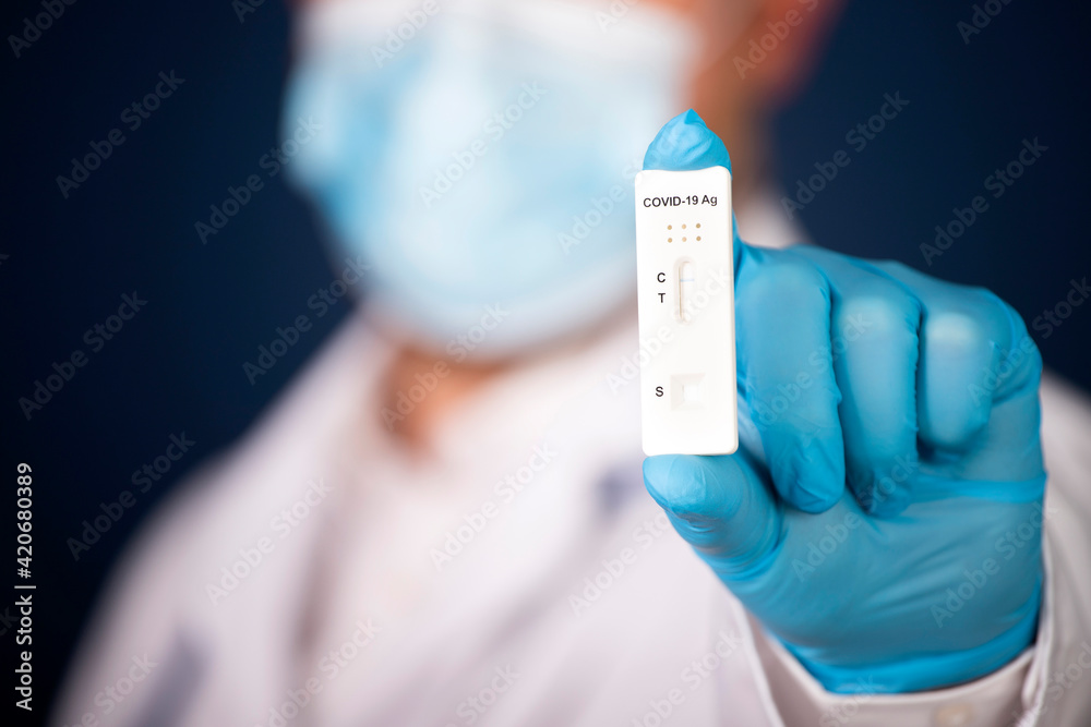 Medic hands in gloves holding negative COVID-19 test, rapid test kit for diagnosis Coronavirus infection