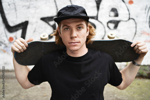 Skater in black clothing with his board photo