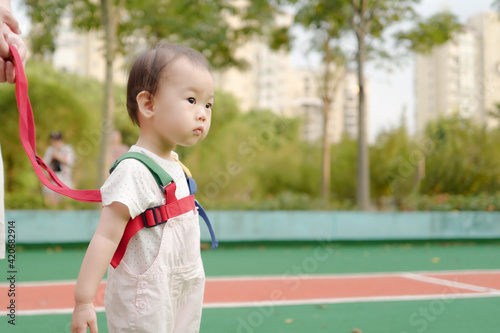 One-year-old baby walking with seat belt photo