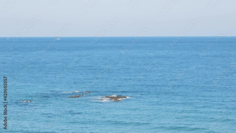Sandy beach with calm blue ocean water at the beach. Sandy beach with calm blue ocean water at the beach.