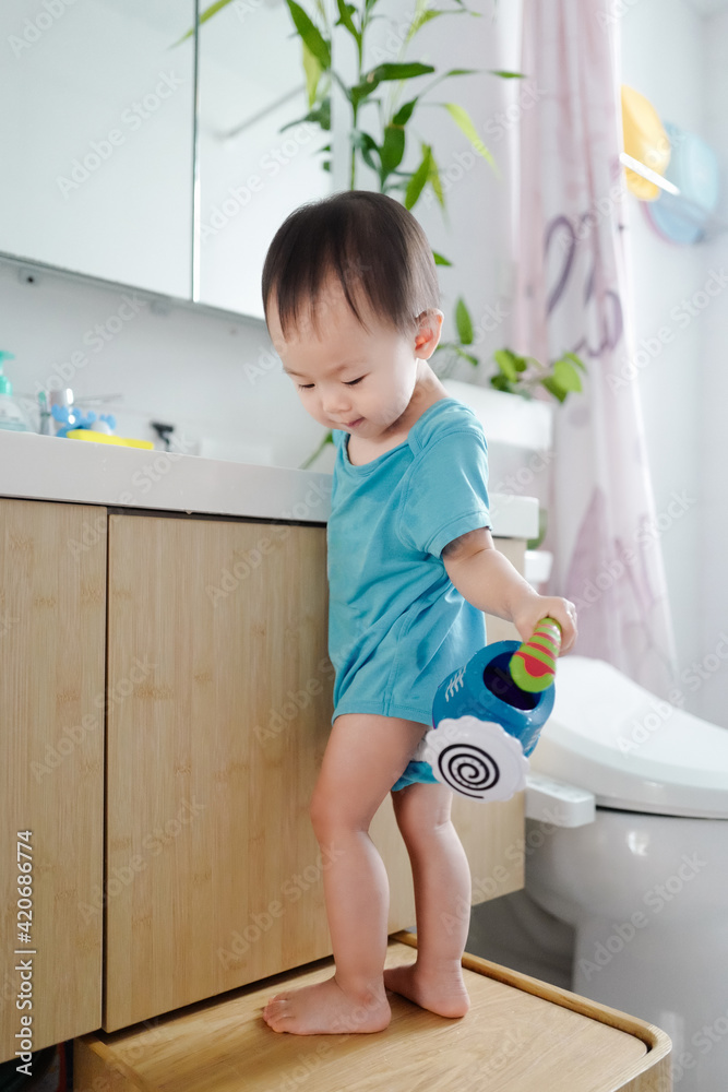 Baby playing with a small kettle at home Baby playing with a small kettle at home