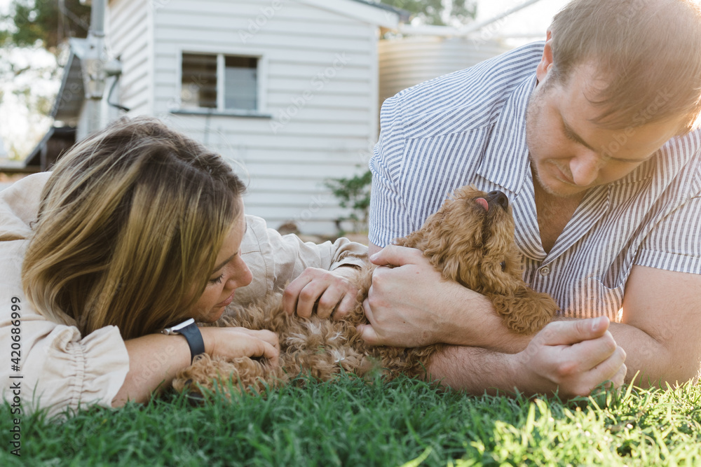 Couple cuddle and hold their puppy Couple cuddle and hold their puppy